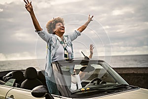 Happy senior couple having fun driving on new convertible car - Mature people enjoying time together during road trip tour