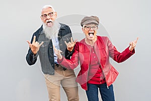 Happy senior couple having fun together outdoor - Retired man and woman celebrating crazy moments