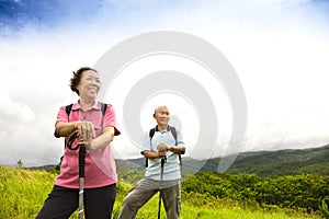 Happy senior couple hiking on the mountain