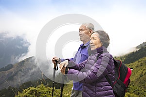 Happy senior couple hiking on the mountain