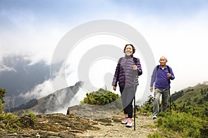 Happy senior couple hiking on the mountain