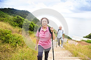 Happy senior couple hiking on the mountain park