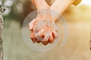 Happy senior couple holding hands. hands of man and woman hold each other. romance and love and support in elderly family. faceles