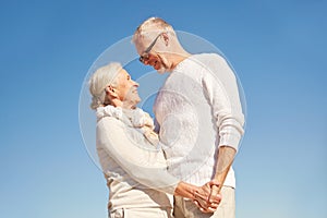 Happy senior couple holding hands outdoors