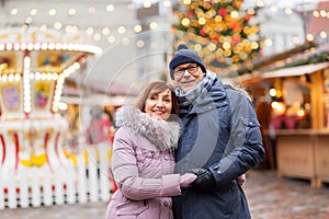 Happy senior couple hugging at christmas market