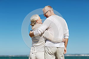 Happy senior couple hugging on summer beach