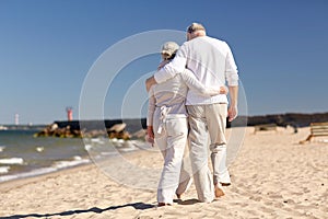 Happy senior couple hugging on summer beach