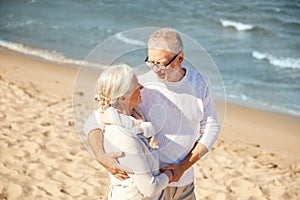 Happy senior couple hugging on summer beach