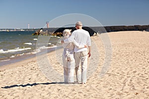 Happy senior couple hugging on summer beach