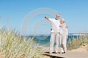 Happy senior couple hugging on summer beach