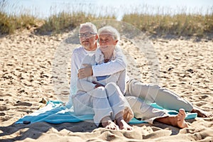 Happy senior couple hugging on summer beach