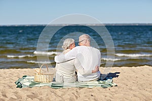 Happy senior couple hugging on summer beach