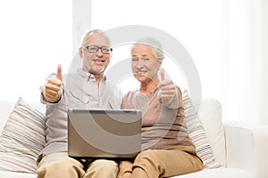 Happy senior couple with laptop at home