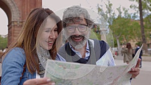 Happy senior couple looking a map while sightseeing Barcelona city.