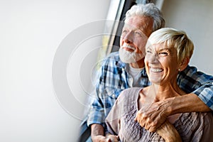 Happy senior couple in love hugging and bonding with true emotions at home