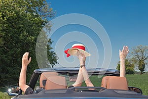 Happy senior couple with a luxury convertible car