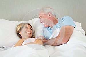 Happy senior couple lying on bed