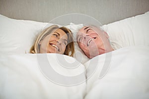 Happy senior couple lying on bed