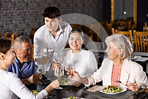 Happy senior couple meeting with adult children in restaurant