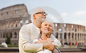 Happy senior couple over coliseum in rome, italy