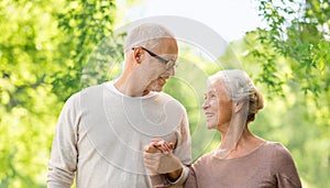 Happy senior couple over green natural background