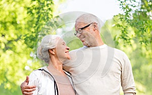 Happy senior couple over green natural background