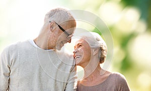 Happy senior couple over green natural background