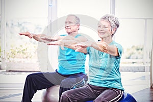 Happy senior couple performing exercise