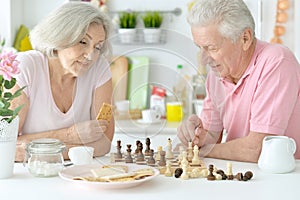 Happy senior couple playing chess