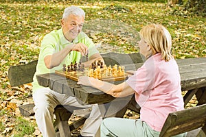 Happy senior couple playing chess