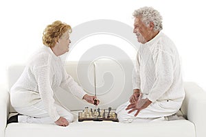 Happy senior couple playing chess