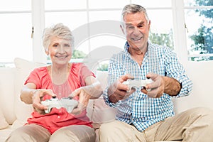 Happy senior couple playing video games