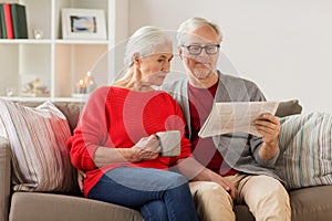 Happy senior couple reading newspaper at christmas photo