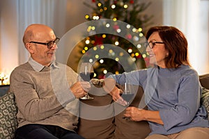 happy senior couple with red wine on christmas