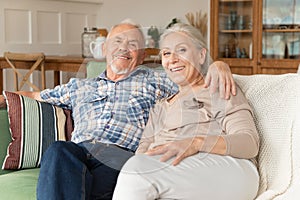 Happy senior couple rest on sofa at home