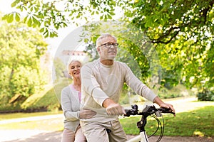 Happy senior couple riding on bicycle at park