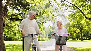 Happy senior couple riding bicycles at summer park