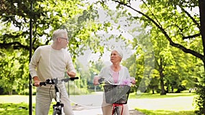 Happy senior couple riding bicycles at summer park