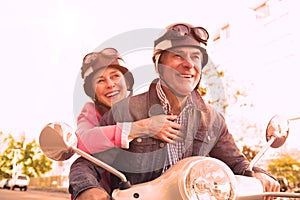 Happy senior couple riding a moped