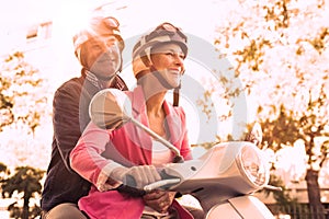 Happy senior couple riding a moped