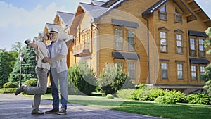 Happy senior couple showing keys to new big house