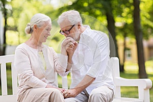 Happy senior couple sitting on bench at park