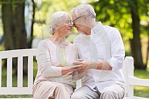 Happy senior couple sitting on bench at park
