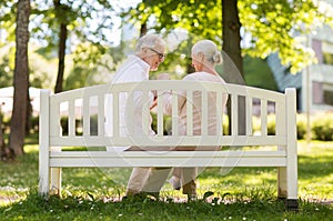 Happy senior couple sitting on bench at park