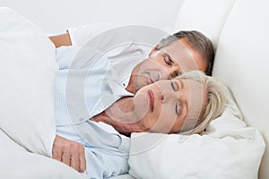Happy senior couple on sleeping bed