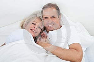 Happy senior couple on sleeping bed