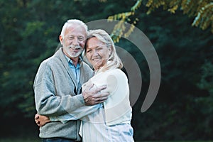 Happy senior couple smiling outdoors in nature