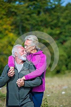 Happy senior couple smiling outdoors in nature. Grandparents, autumn.