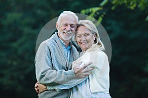 Happy senior couple smiling outdoors in nature