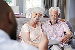 Happy senior couple taking financial advice at home